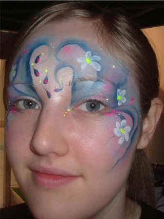 Face Painting: Adult female with silver and blue princess face punctuated with delicate daisies.