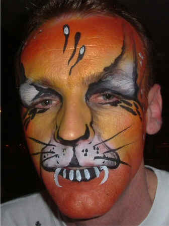 Face Painting: Adult male with orange tiger face with particularly prominent markings for distant viewing.